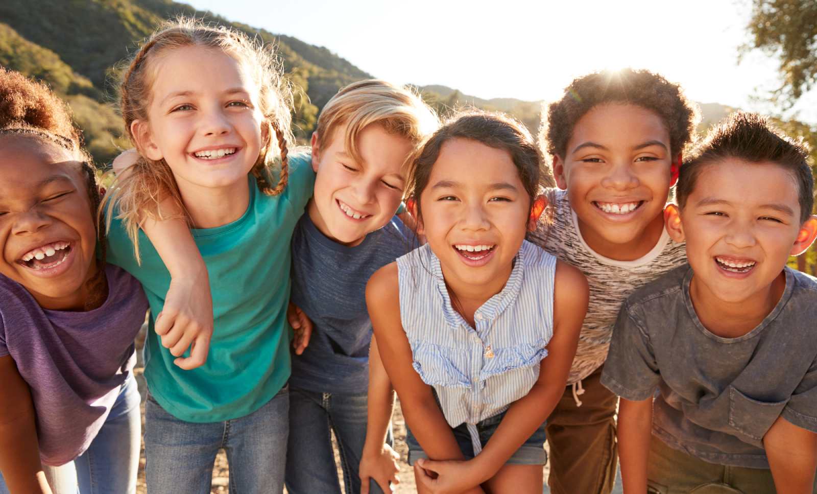 Six children huddled together smiling