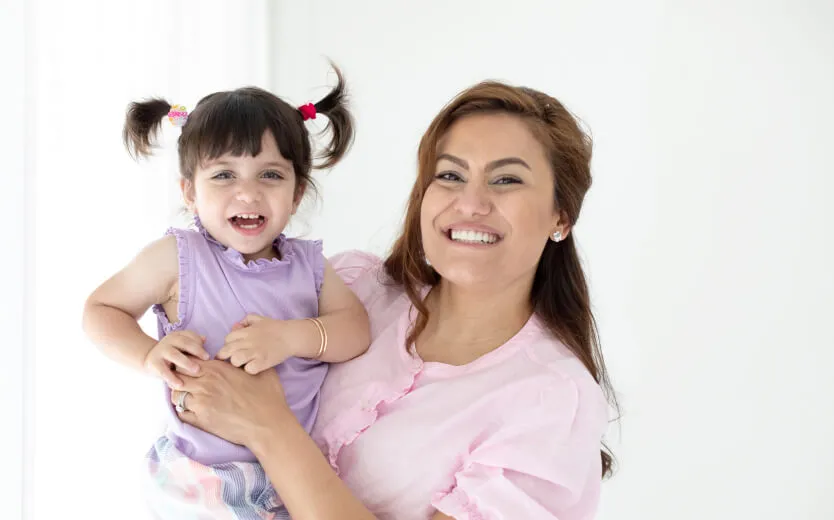 Woman holding young girl and smiling