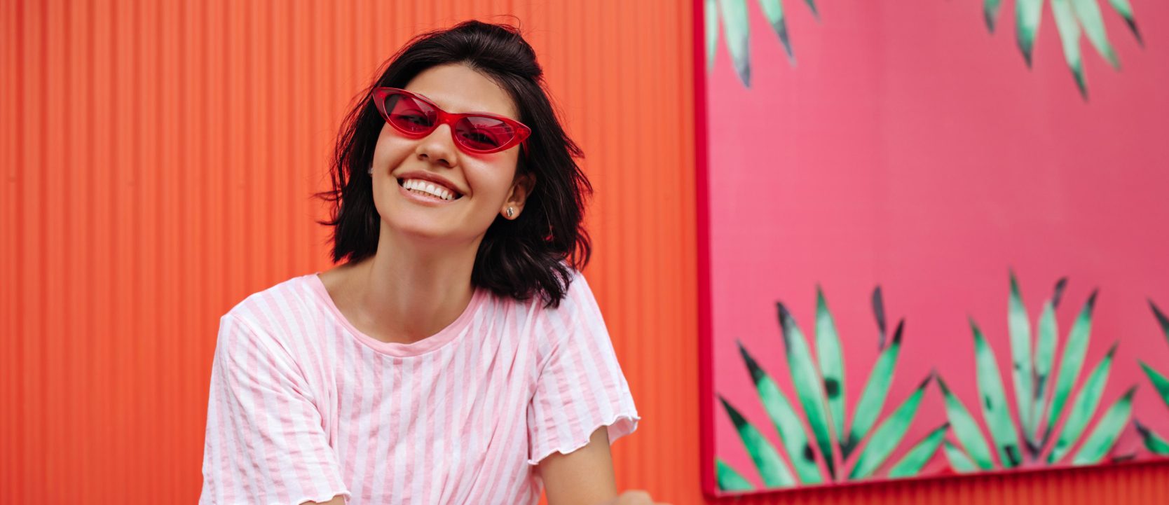 Woman wearing red sunglasses and smiling